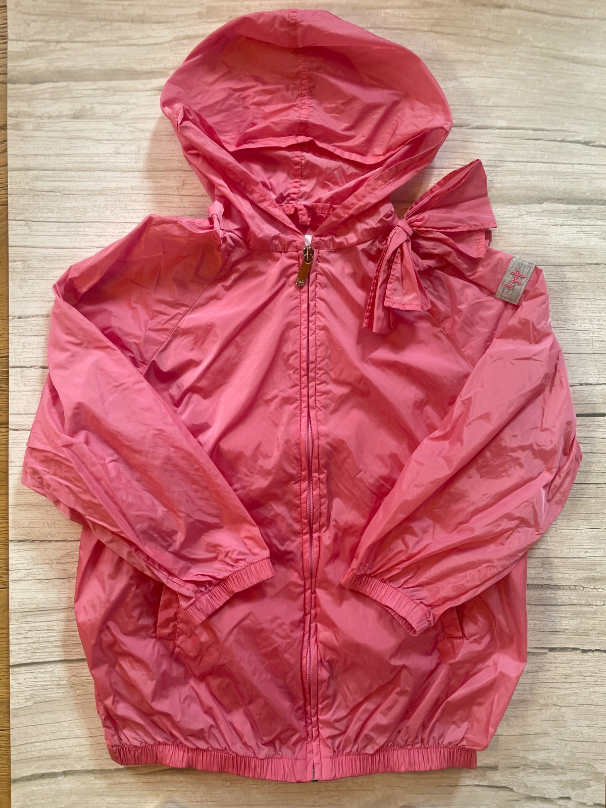 Giacca a vento rosa con cappuccio e fiocco