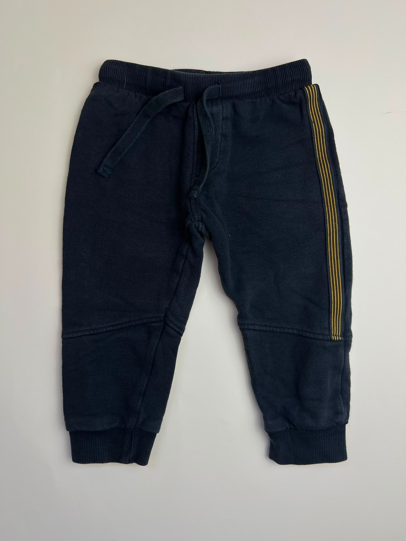 Pantaloni della tuta per bambini nero con strisce laterali gialle