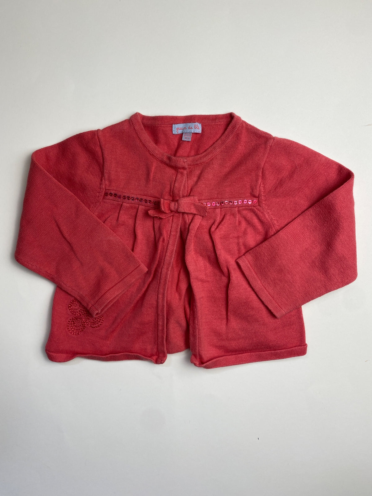 Cardigan rosa corallo con fiocco e paillettes