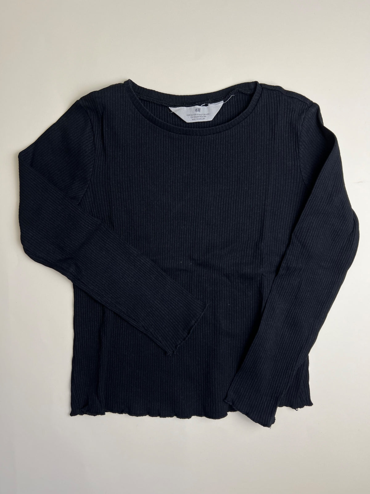 Maglia a maniche lunghe nera a costine con bordo ondulato